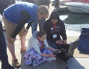 Instructor Axel Gillam leads students to investigate marine invertebrates in the Homer harbor.